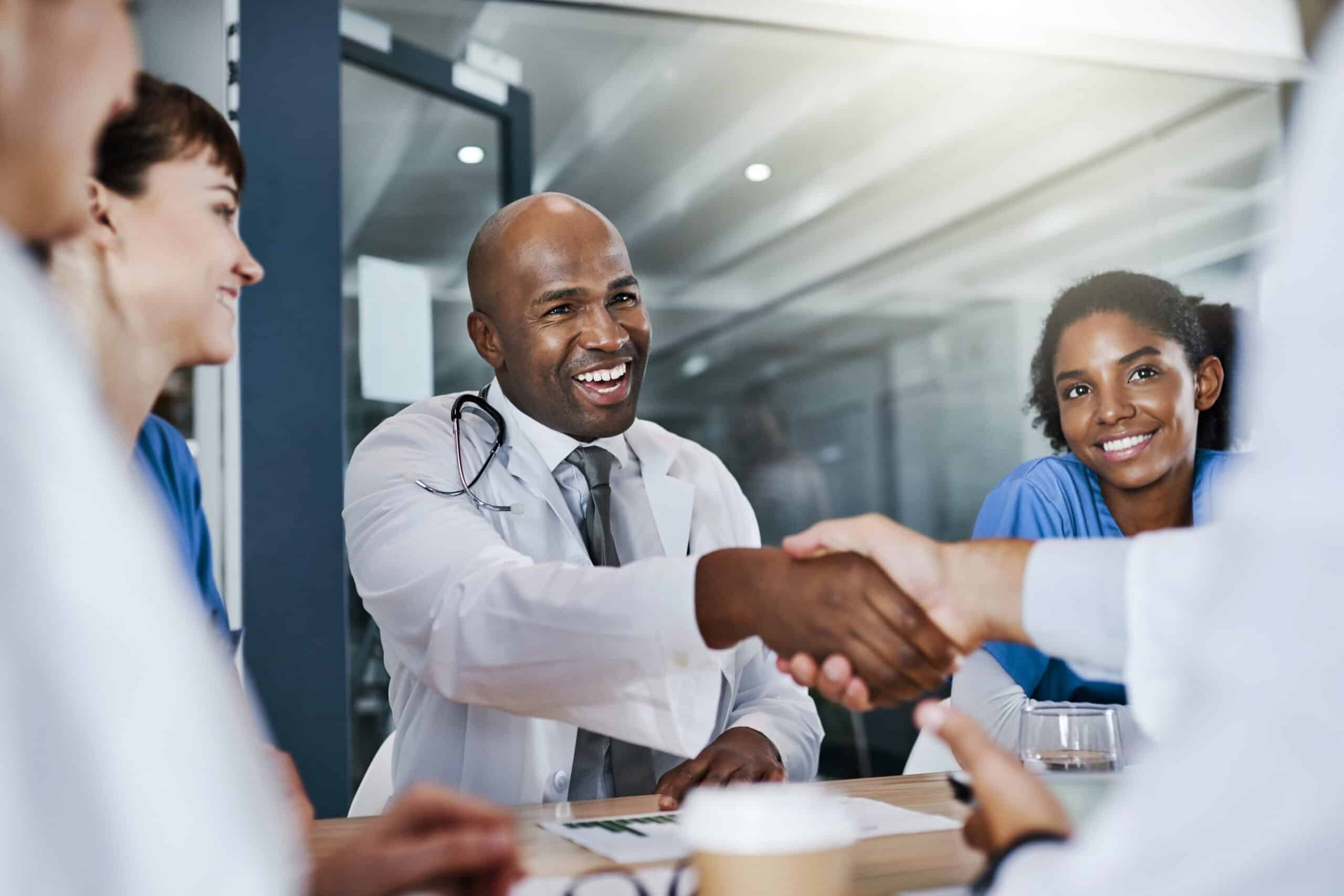 Shot of doctors shaking hands during a meeting in a hospital